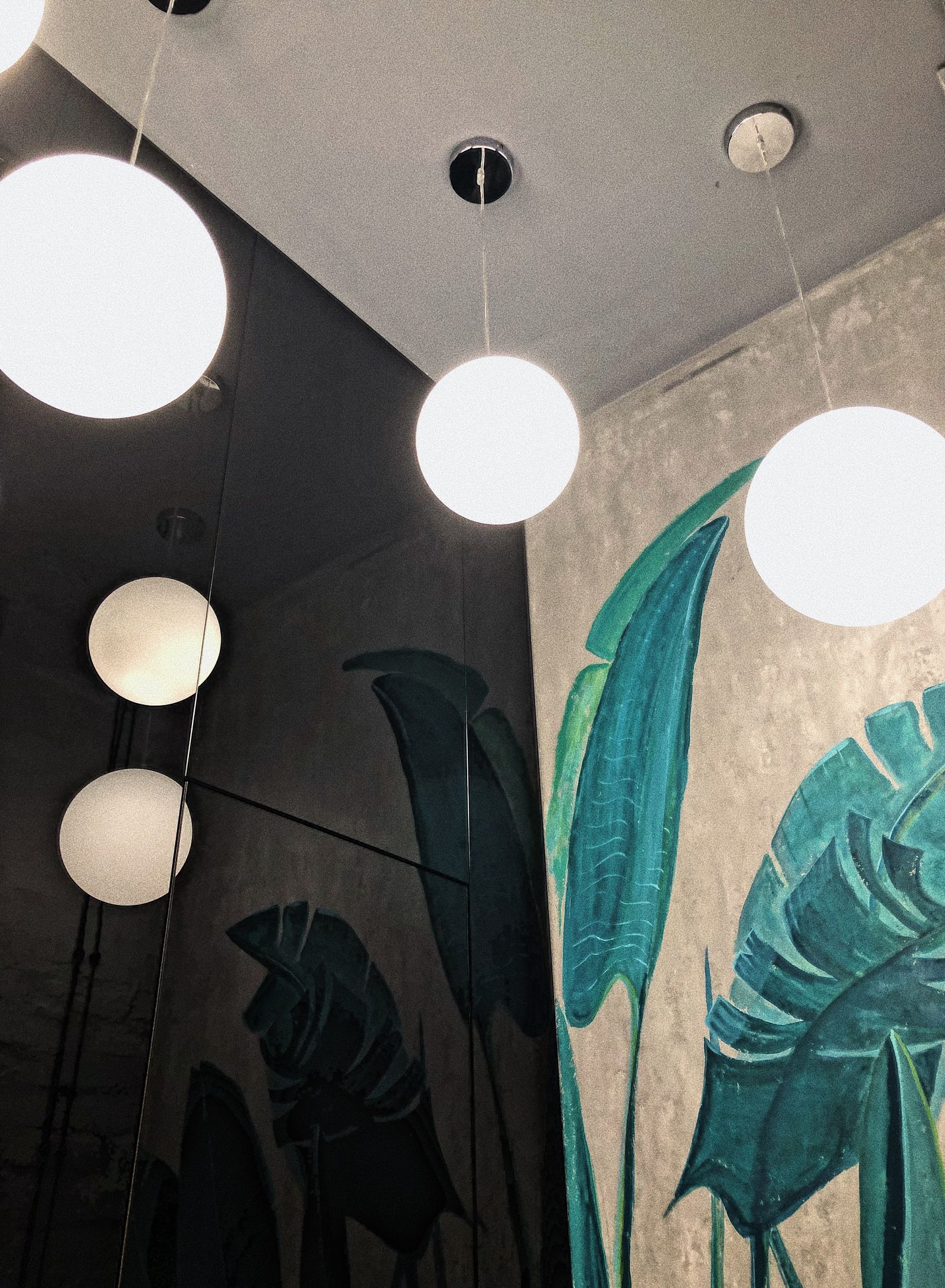 Warm lamp light over a cutting table with pinned campaign proofs in the AdSwift Nest workroom